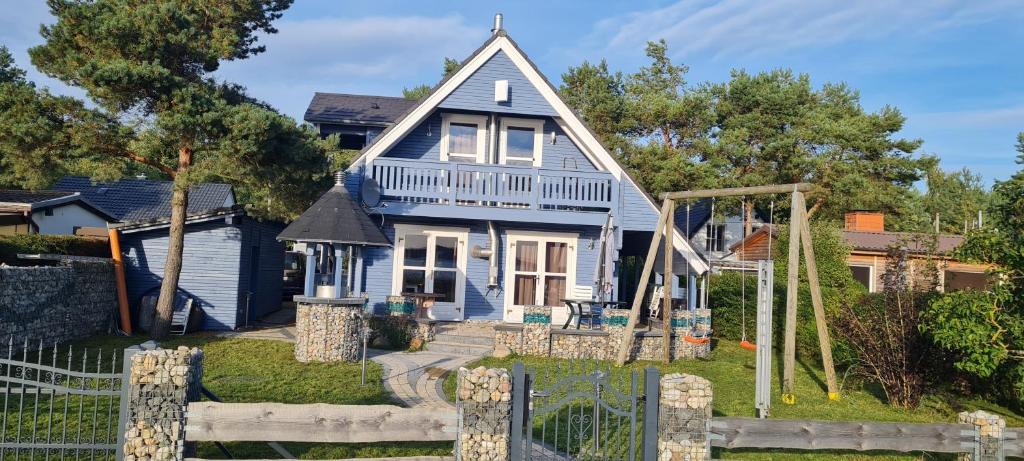 uma casa azul com um parque infantil em frente em Peeneblick em Rankwitz