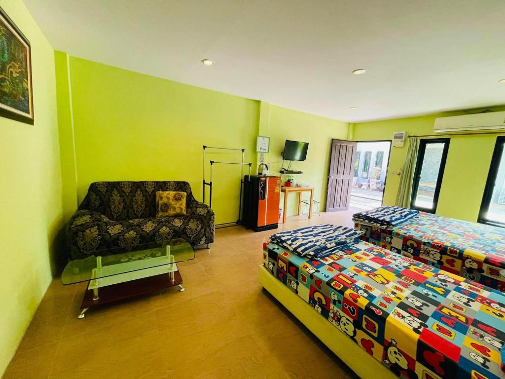 - une chambre avec un lit, un canapé et une chaise dans l'établissement Baan Sri Family, à Kabin Buri