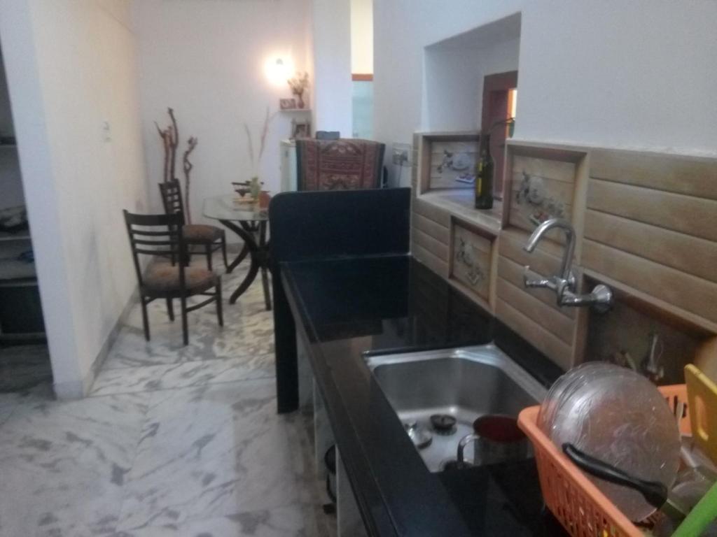 a kitchen with a sink and a table with chairs at La Casa Art Stay in Udaipur