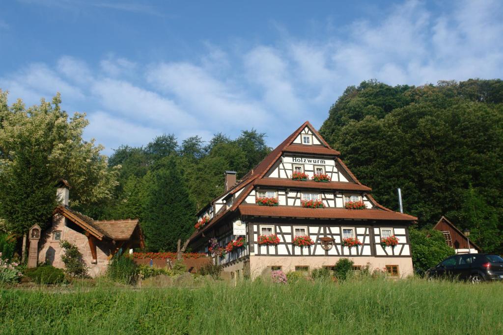 a house with flowers on the windows of it at Naturhotel Holzwurm in Sasbachwalden