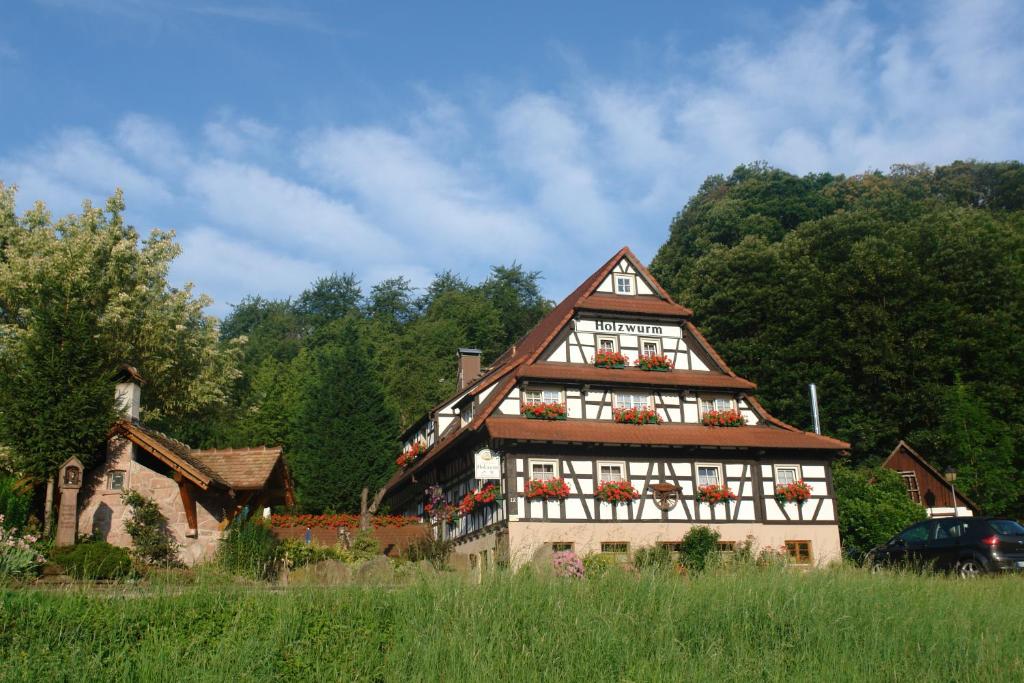 ein Haus mit Blumen an den Fenstern in der Unterkunft Naturhotel Holzwurm in Sasbachwalden