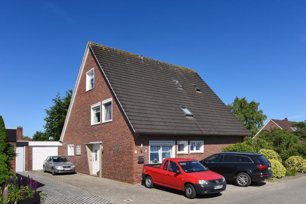 a red car parked in front of a brick house at Ferienwohnung im Haus Fooken in Stedesdorf
