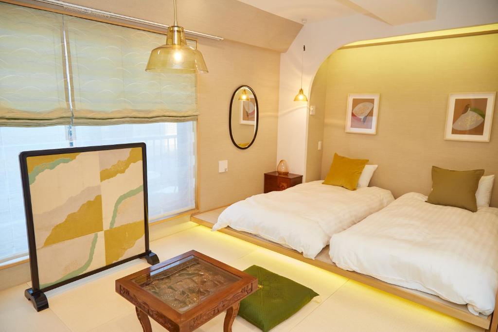 a room with two beds and a table in it at Asakusa New City Hotel in Tokyo