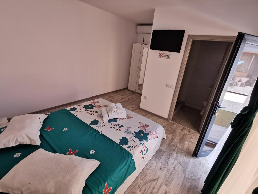 a small bedroom with a bed and a mirror at Casutele Amaliei in Corbu