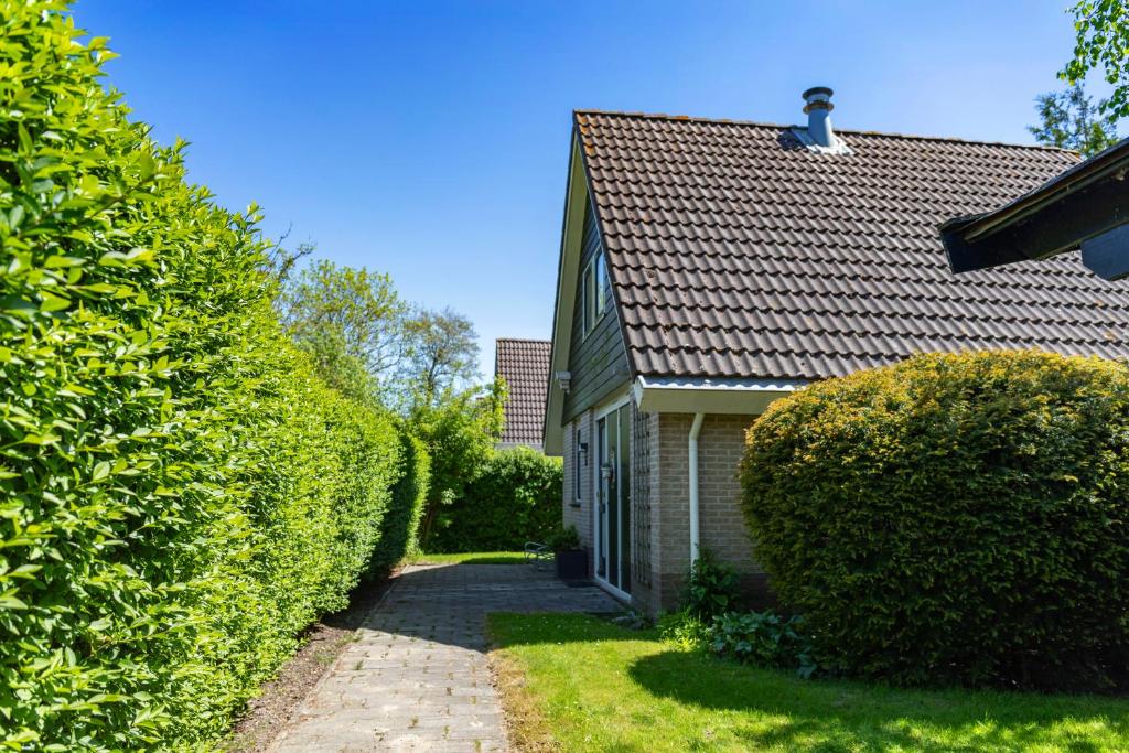 a house with a chimney on top of a roof at Bungalow 36 op Recreatiepark De Wielen in Sint Maarten