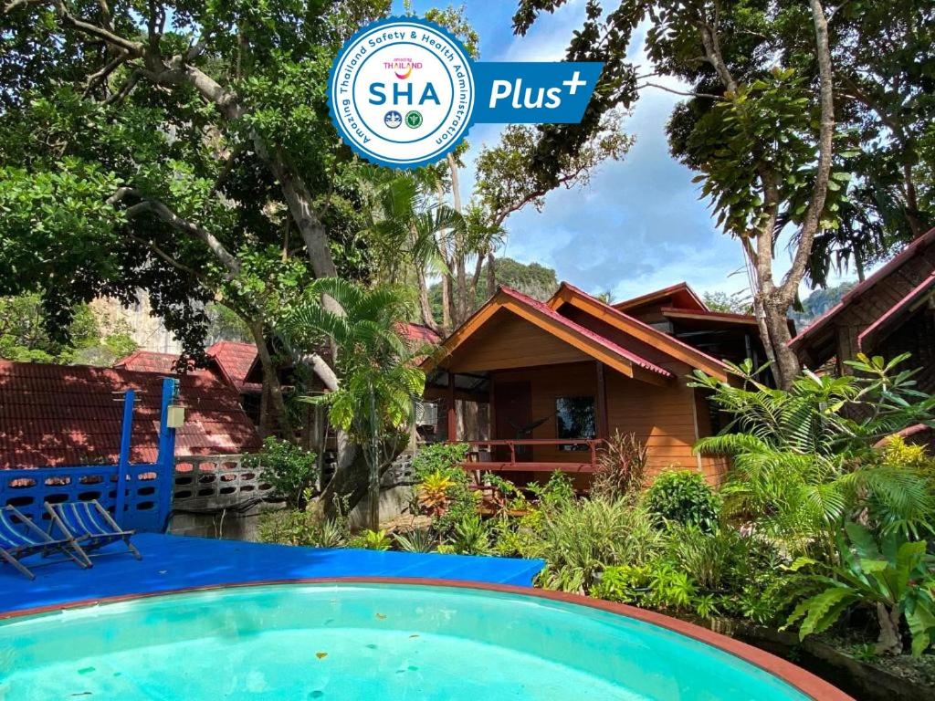 una casa con piscina y un cartel que diga Sla plus en Rapala Rock Wood Resort- SHA Plus en Railay Beach