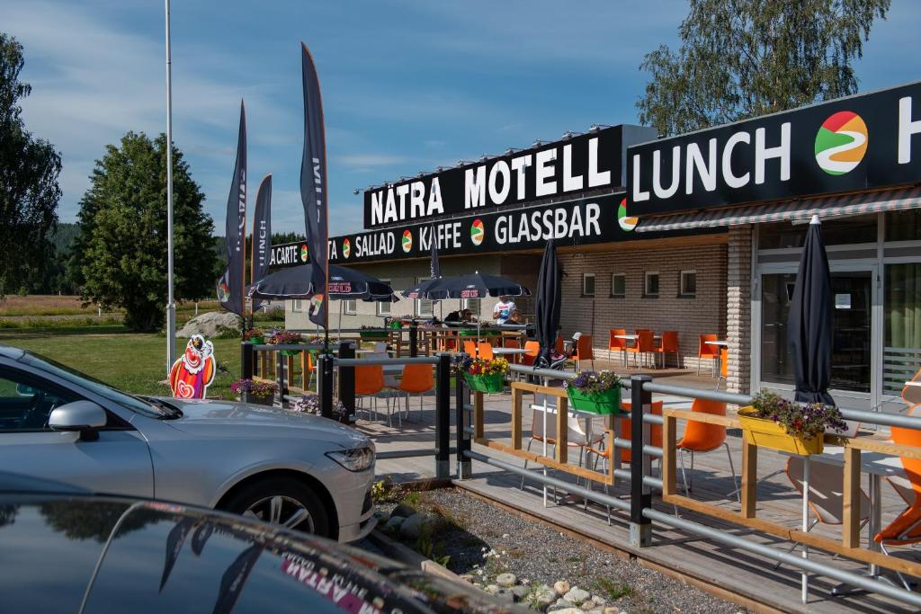 un coche aparcado frente a un restaurante en Nätra Motell, en Bjästa