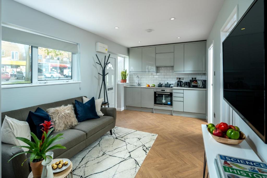 uma sala de estar com um sofá e uma cozinha em Skyline Serviced Apartments - Flat A Rockingham Way em Stevenage