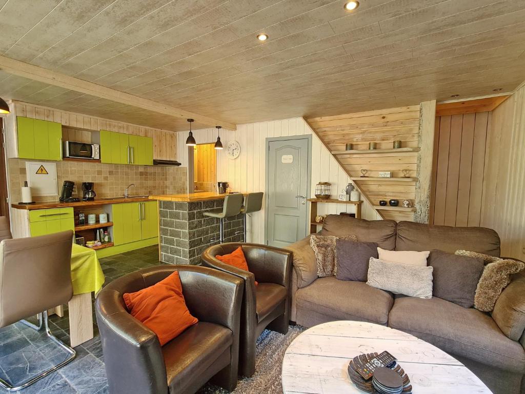 a living room with a couch and chairs and a kitchen at Chalet Cato in Durbuy