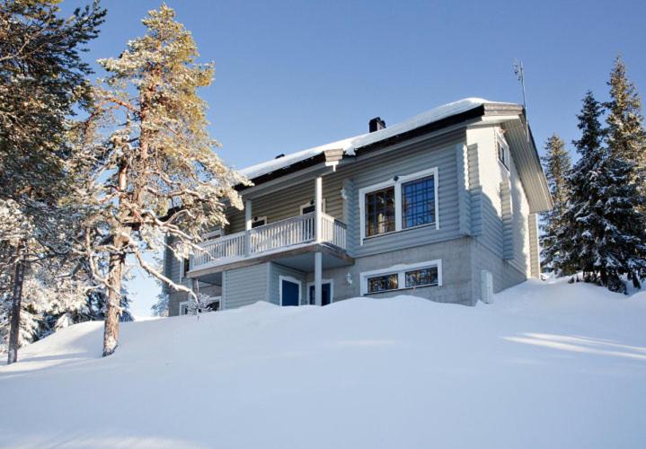 a house in the snow with a pile of snow at Kotamäki A in Syöte