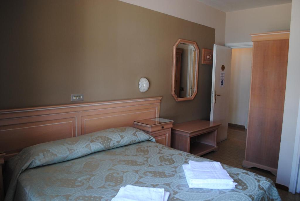 a bedroom with a bed with two towels on it at Hotel Esperia in Lazise