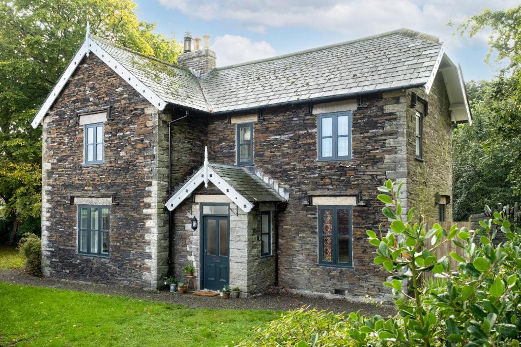 una vieja casa de ladrillo con una puerta azul en Finest Retreats - North Lodge en Cockermouth