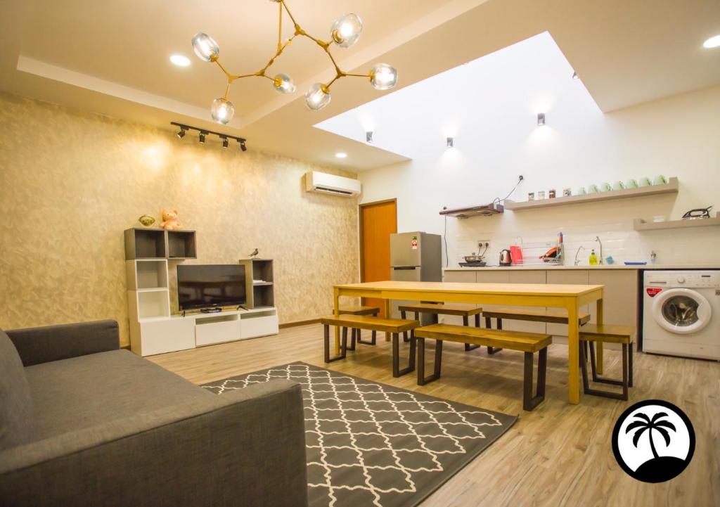 ein Wohnzimmer mit einem Tisch und einer Küche in der Unterkunft Paradise Suite at Asiacity in Kota Kinabalu