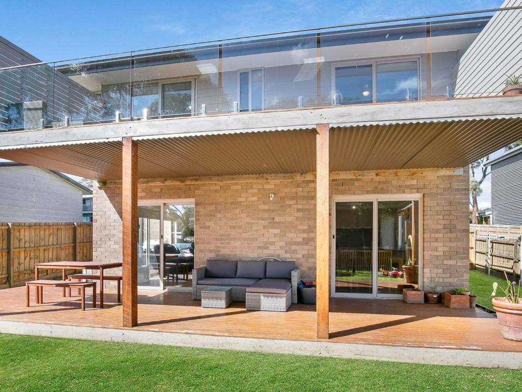 a house with a patio with a couch and a table at The Bay House in Corinella