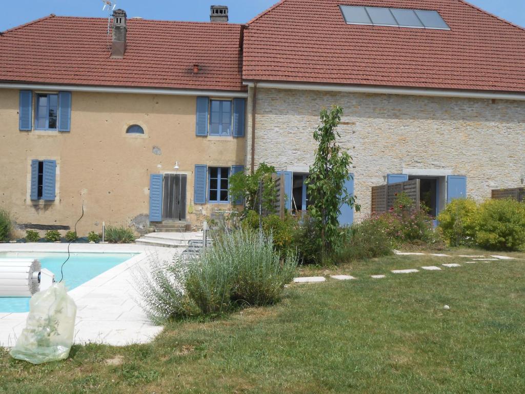 uma casa com um saco plástico ao lado de uma piscina em Les Grands Prés em Geney