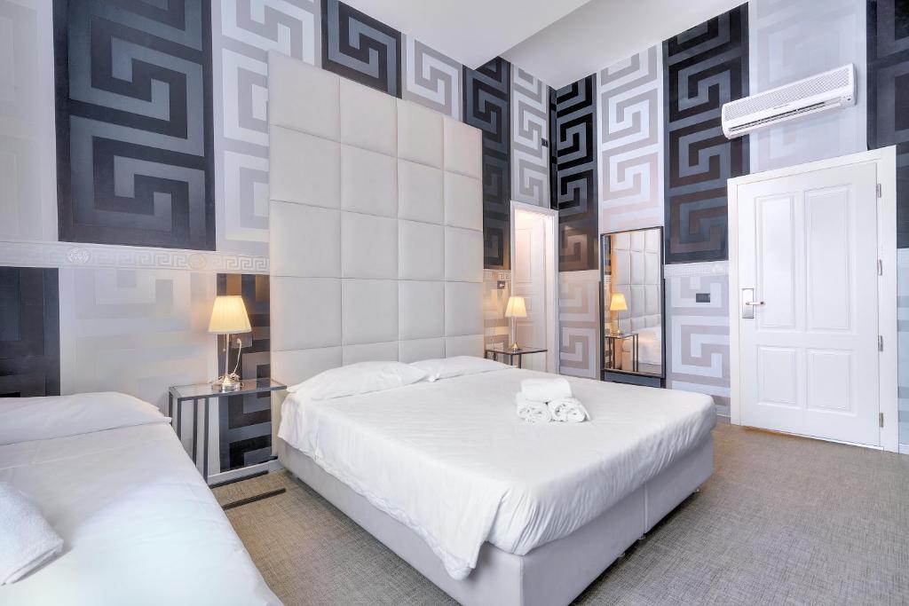 1 dormitorio con 2 camas y una pared con estampados en Hotel Argentina en Florence