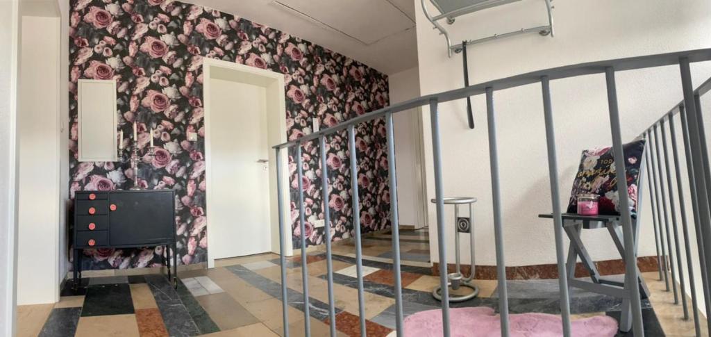 a room with a staircase with a floral wallpaper at Erica Ferienwohnung auf dem Traumpfad in Ettringen
