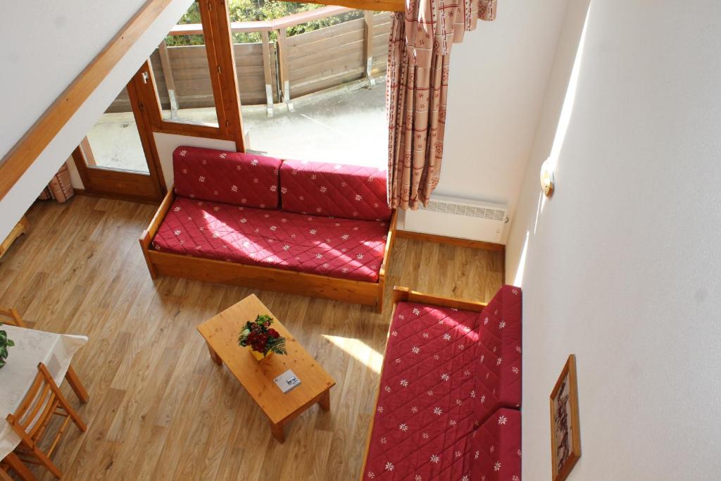 een woonkamer met een rode bank en een tafel bij Résidence Saboia B54 Clés Blanches Courchevel in La Tania