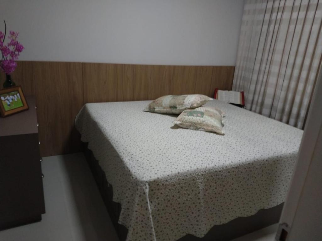 ein kleines Bett mit zwei Kissen darauf in einem Zimmer in der Unterkunft Apartamento Completo Família Gravata Navegantes SC Beto Carreiro in Navegantes