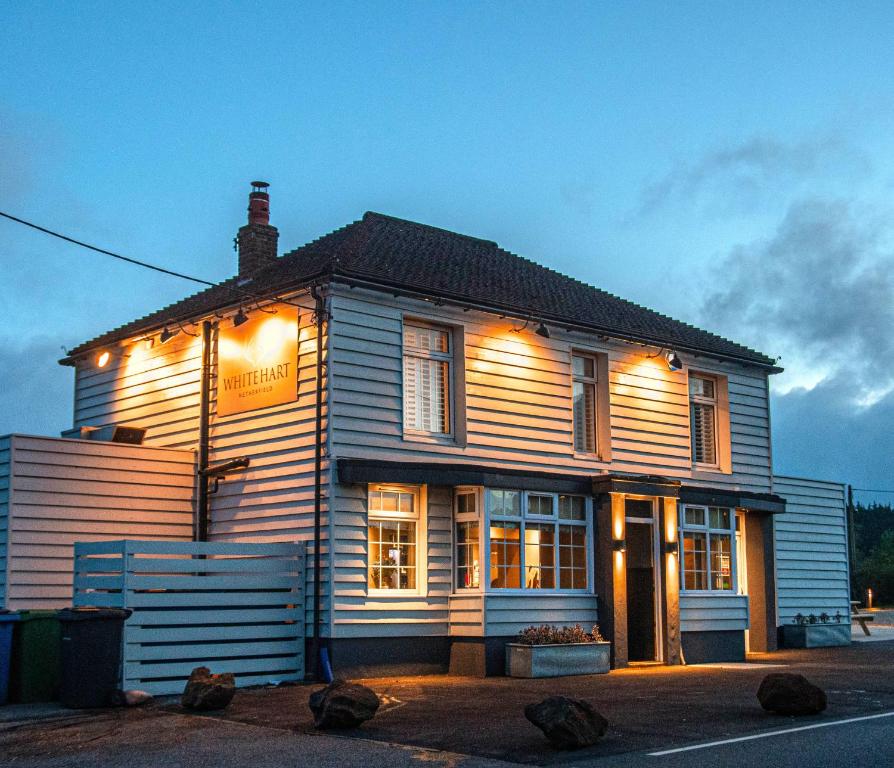 un edificio con luces en el lateral. en White Hart Inn en Brightling