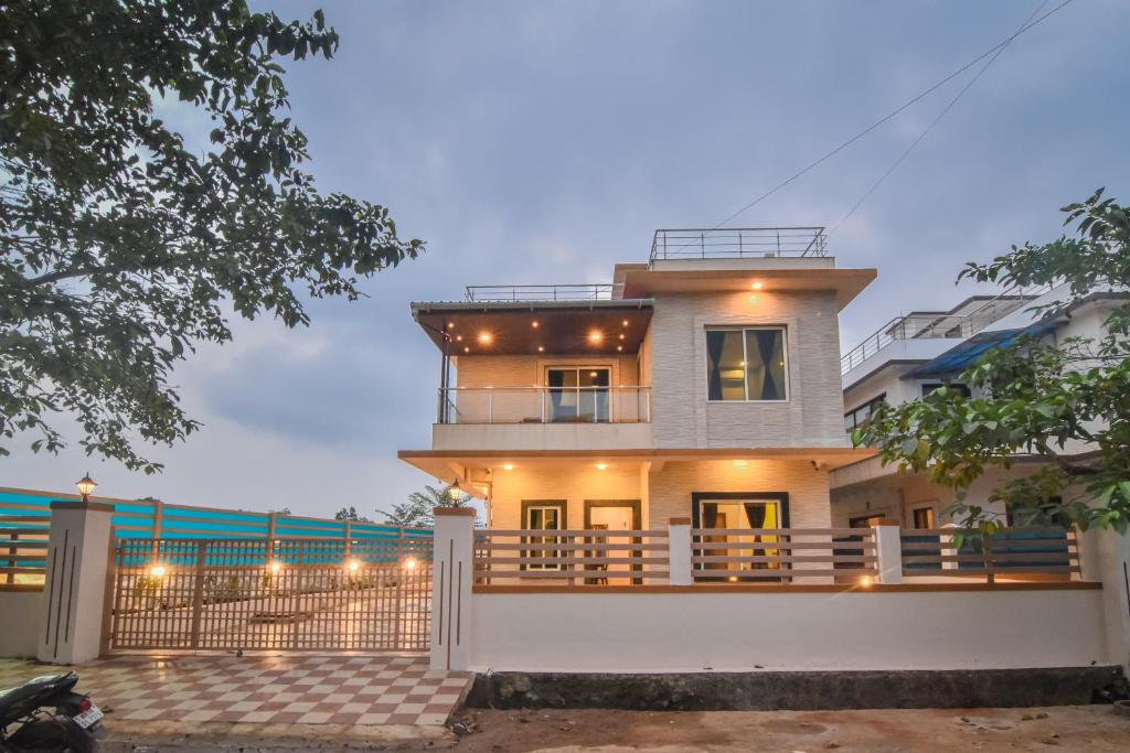 a house with a balcony and a fence at H2O Greens Villa in Lonavala