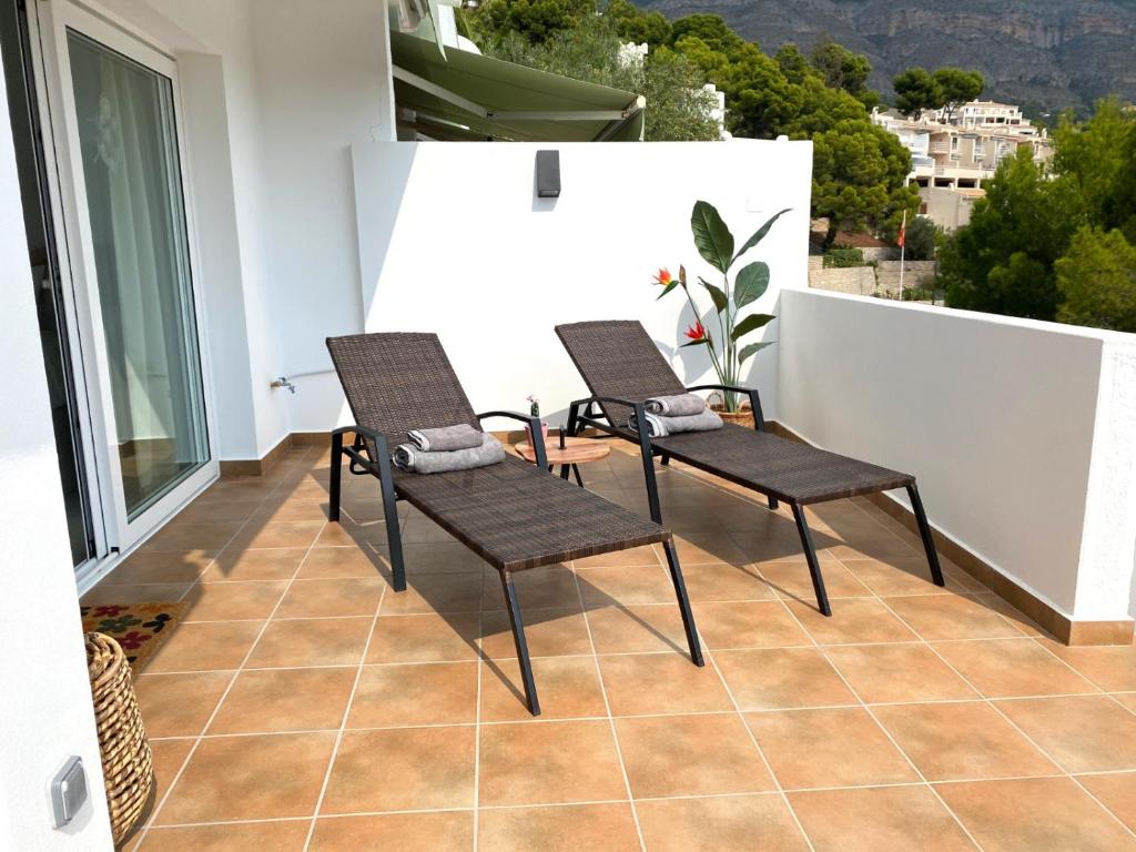 Duas cadeiras e uma mesa numa varanda em Ama Vida Altea apartment with panoramic view em Altea