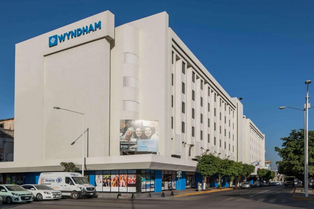 a large white building with a sign on it at Wyndham Executivo Culiacan in Culiacán