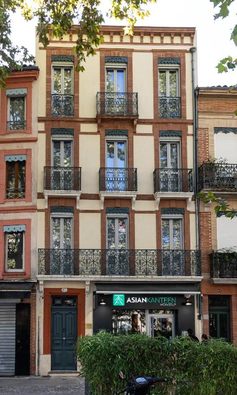 un immeuble d'appartements avec balcon dans une rue de la ville dans l'établissement Residence le Pastel Jeanne d'Arc, à Toulouse