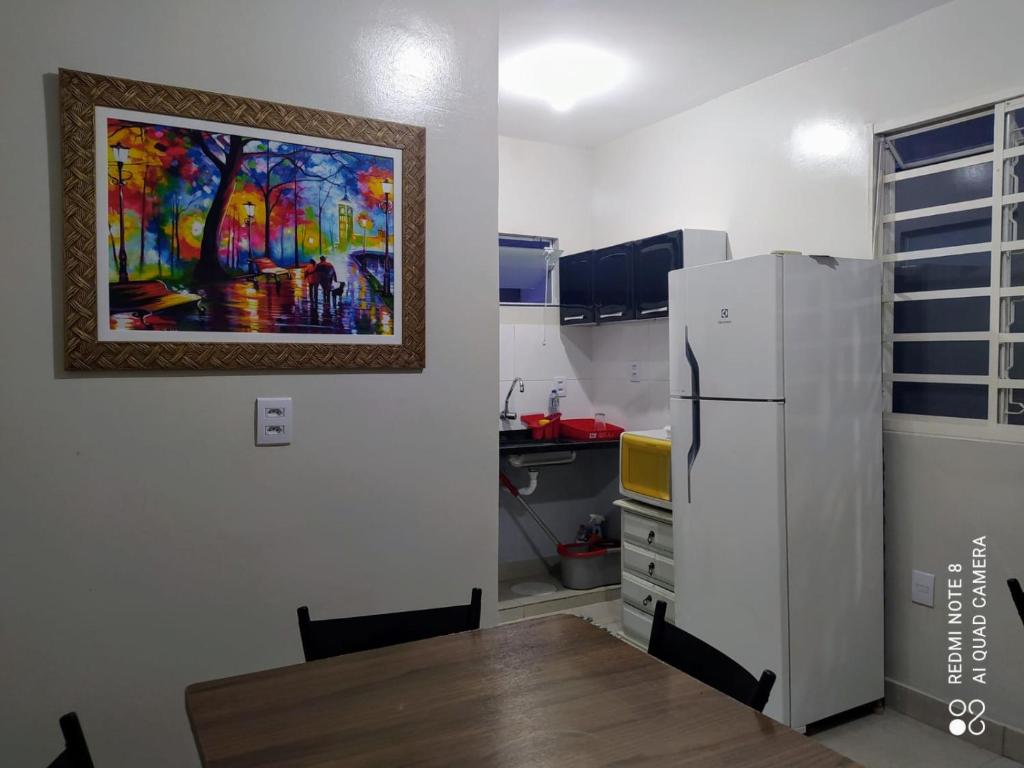 una cocina con una mesa y una pintura en la pared en Pousada Dona Lia, en Uberlândia