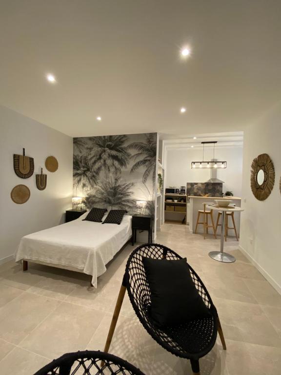 een slaapkamer met een bed en een stoel bij Anne de la Maison Blanche in Avignon