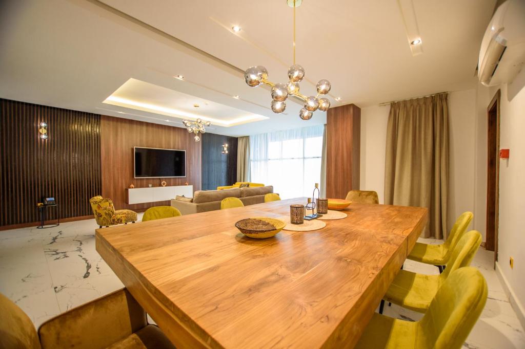 a dining room with a large wooden table and chairs at ART Residence in Porto-Novo
