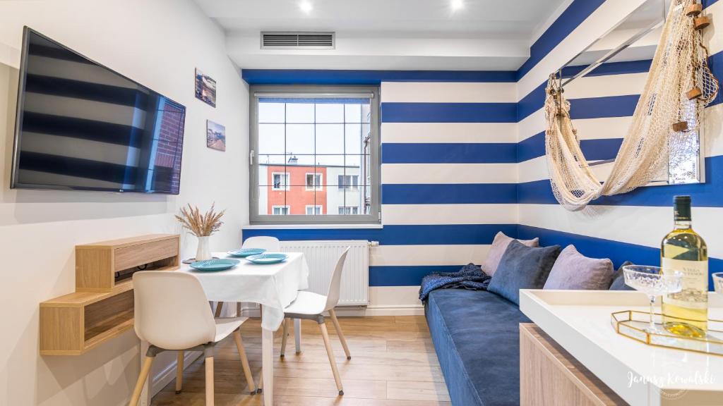 a living room with a blue and white striped wall at Apartament 117 HVILE in Gdańsk