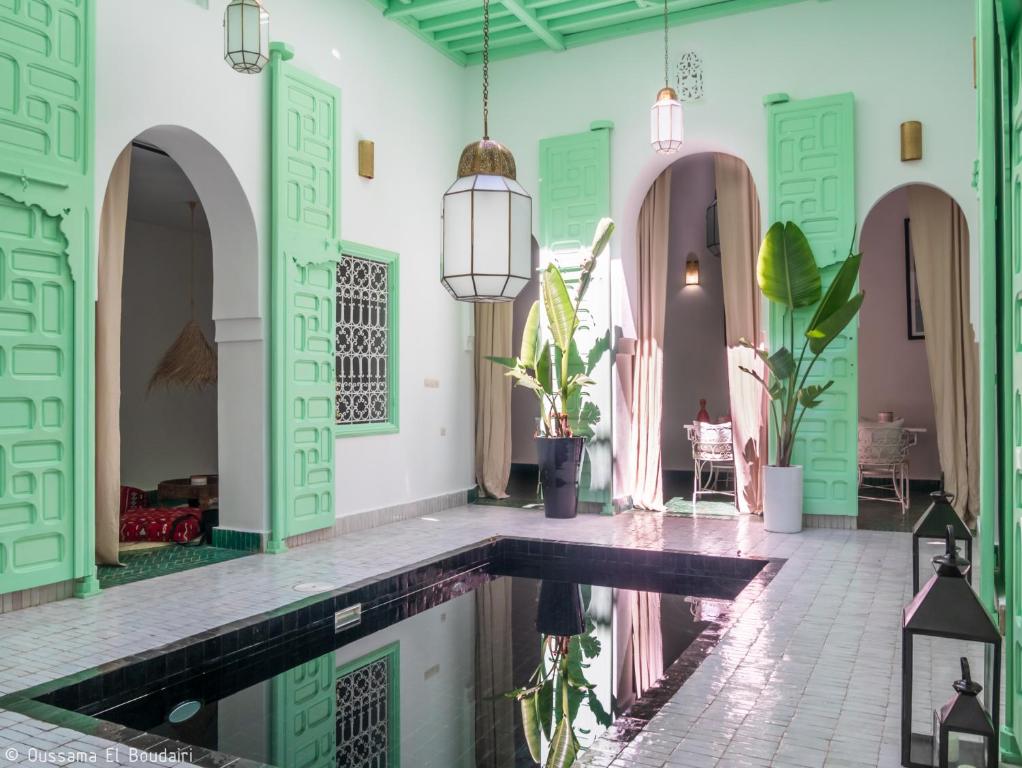 a swimming pool in a house with green and white walls at Riad Dar Rabiaa in Rabat