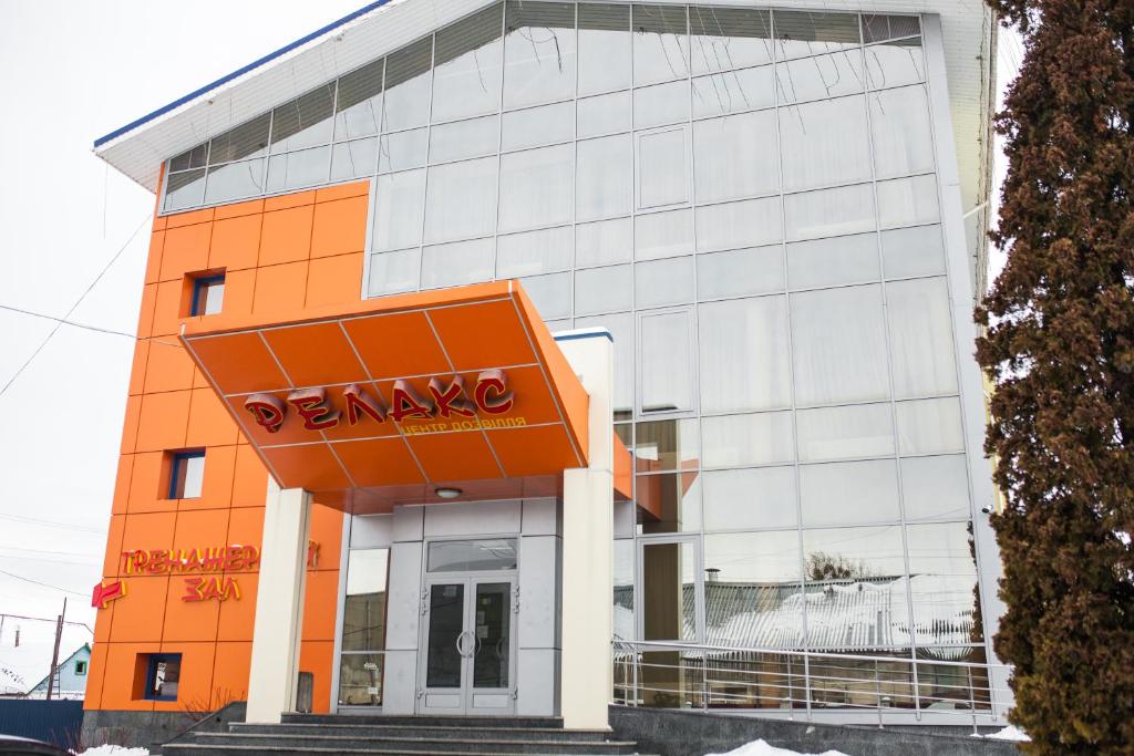 un edificio naranja y blanco con un cartel en él en Готель Релакс en Korostyshiv