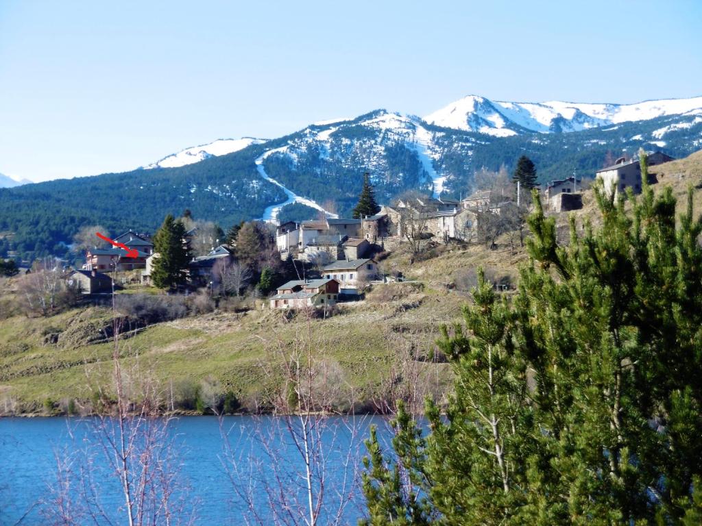 a town on a hill next to a body of water at Le logis des cerfs in Puyvalador