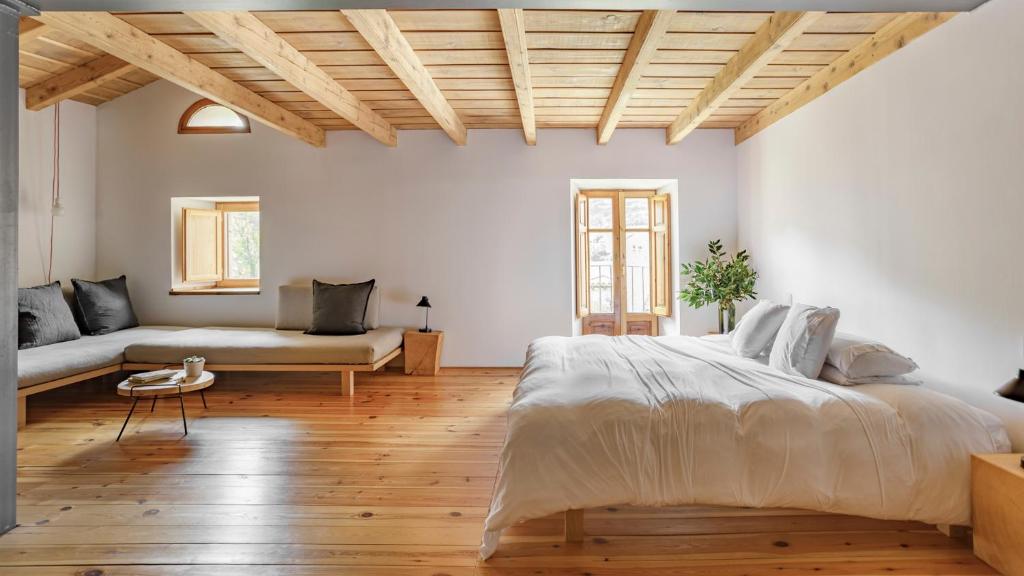 ein Schlafzimmer mit einem großen Bett und einem Sofa in der Unterkunft Cal Calsot Casa Rural "Adults Only" in Montellá