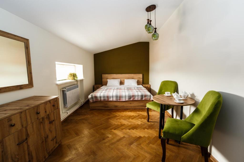 sypialnia z łóżkiem, stołem i krzesłami w obiekcie Red castle w Erywaniu
