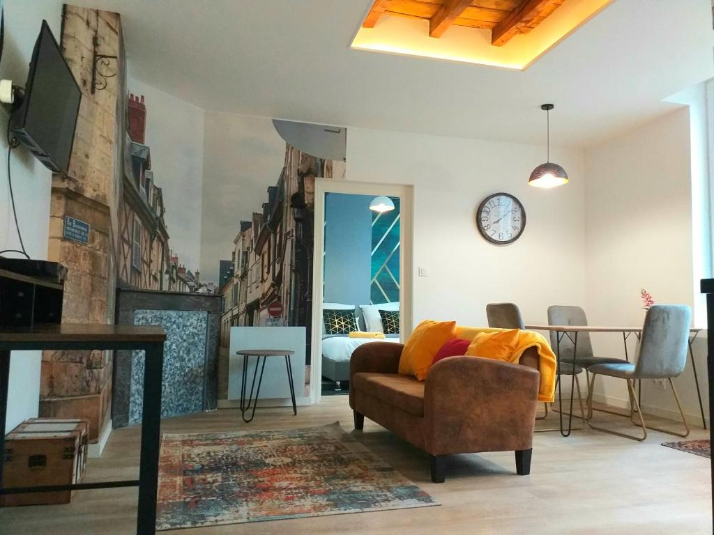 a living room with a couch and a table at Les Volets Bleus - Refaits à neuf, deux appartements et un studio, Jardin in Bourges