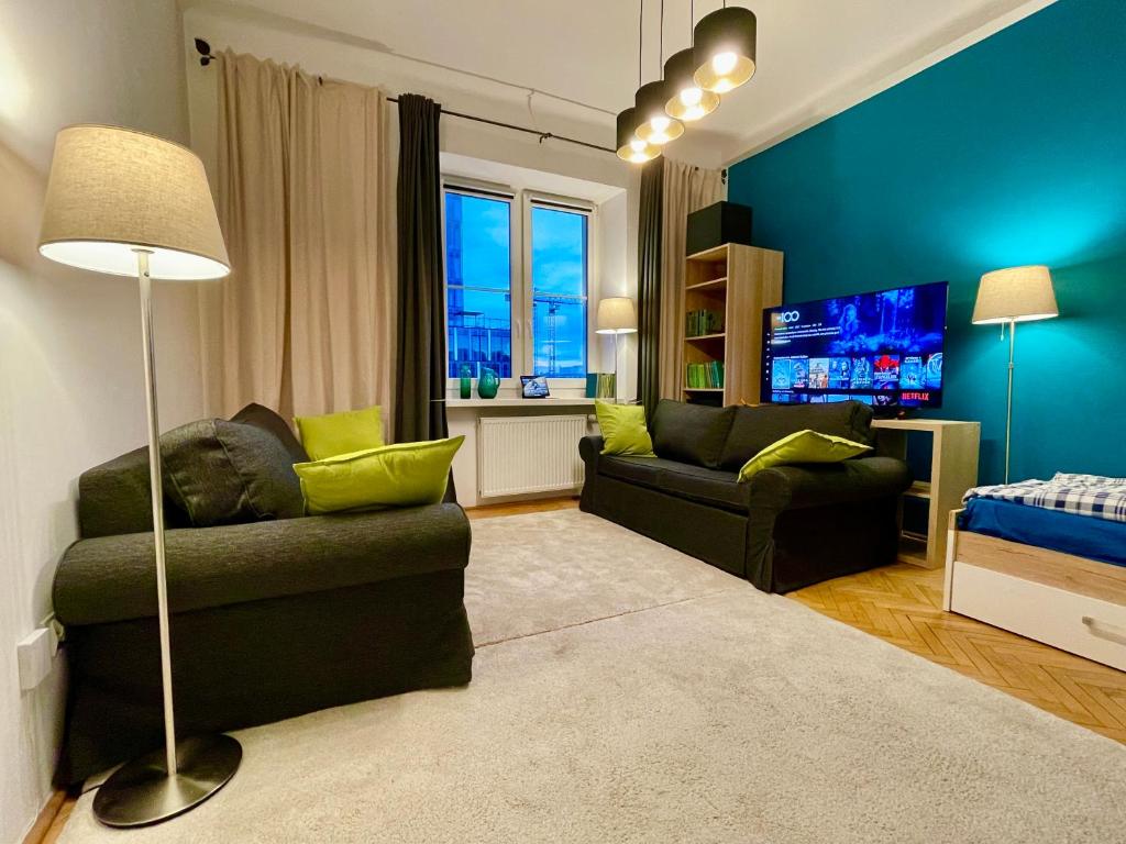 a living room with a couch and a tv at Super SQUARE Metro x2 fast WiFi 55'TV Netflix HBO AppleTV+ AmazonTV in Warsaw