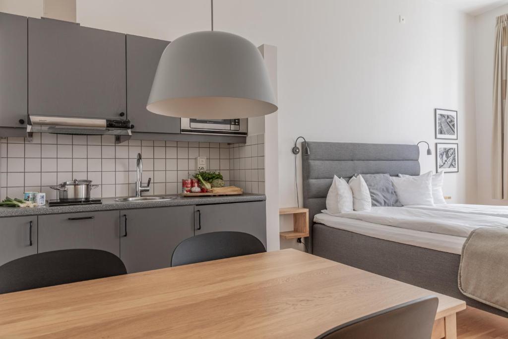 kuchnia i sypialnia z łóżkiem i stołem w obiekcie The More Hotel Mazetti w Malmö