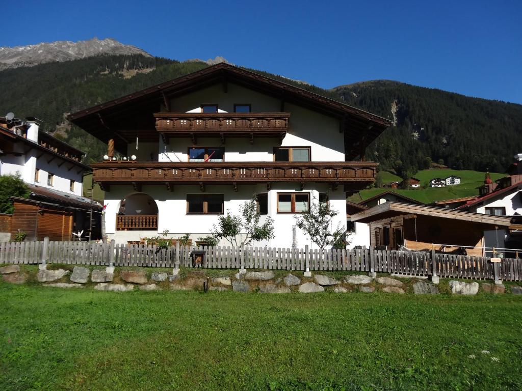 une grande maison avec une clôture devant elle dans l'établissement Ferienwohnung Bergblick, à Gries im Sellrain