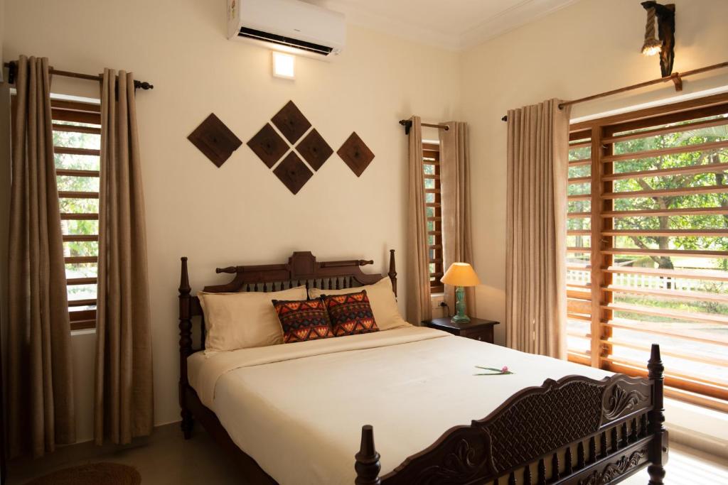 a bedroom with a large bed and a window at POOTHALI HOMESTAY in Nīleshwar