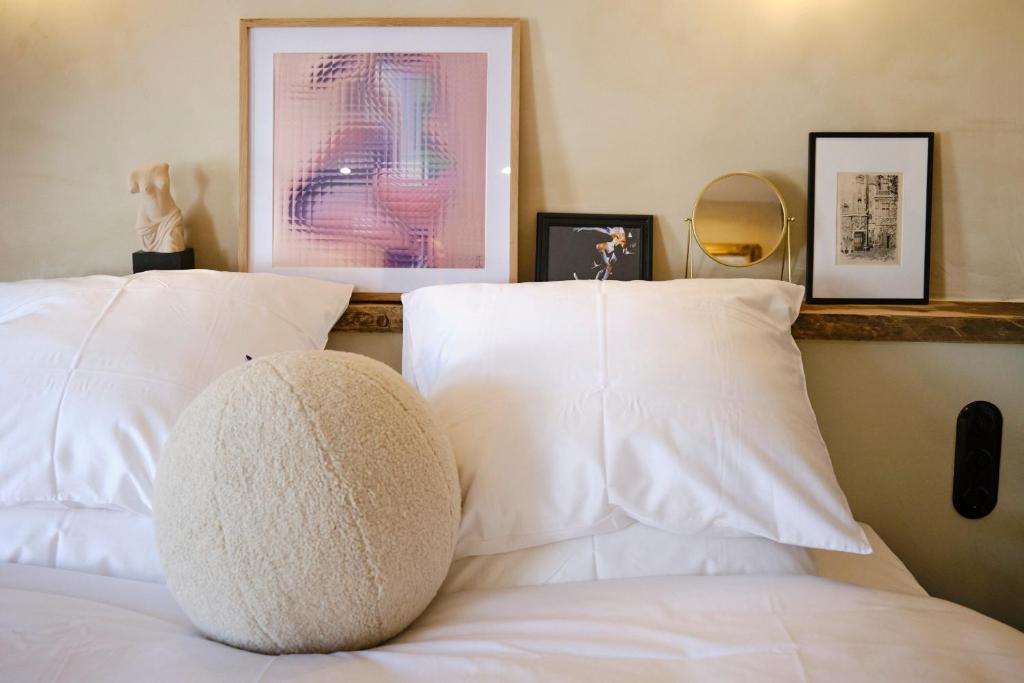 um quarto com uma cama com almofadas brancas em Boutique Hotel & Restaurant Frenchie em Haarlem