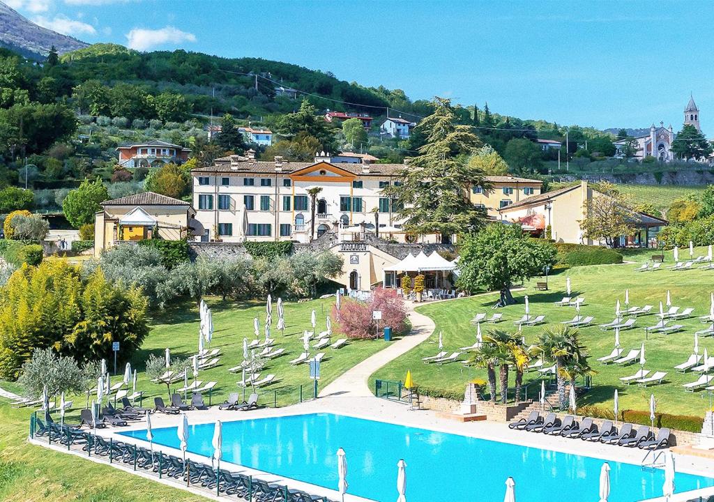 un complejo con piscina y tumbonas en Hotel Villa Cariola, en Caprino Veronese