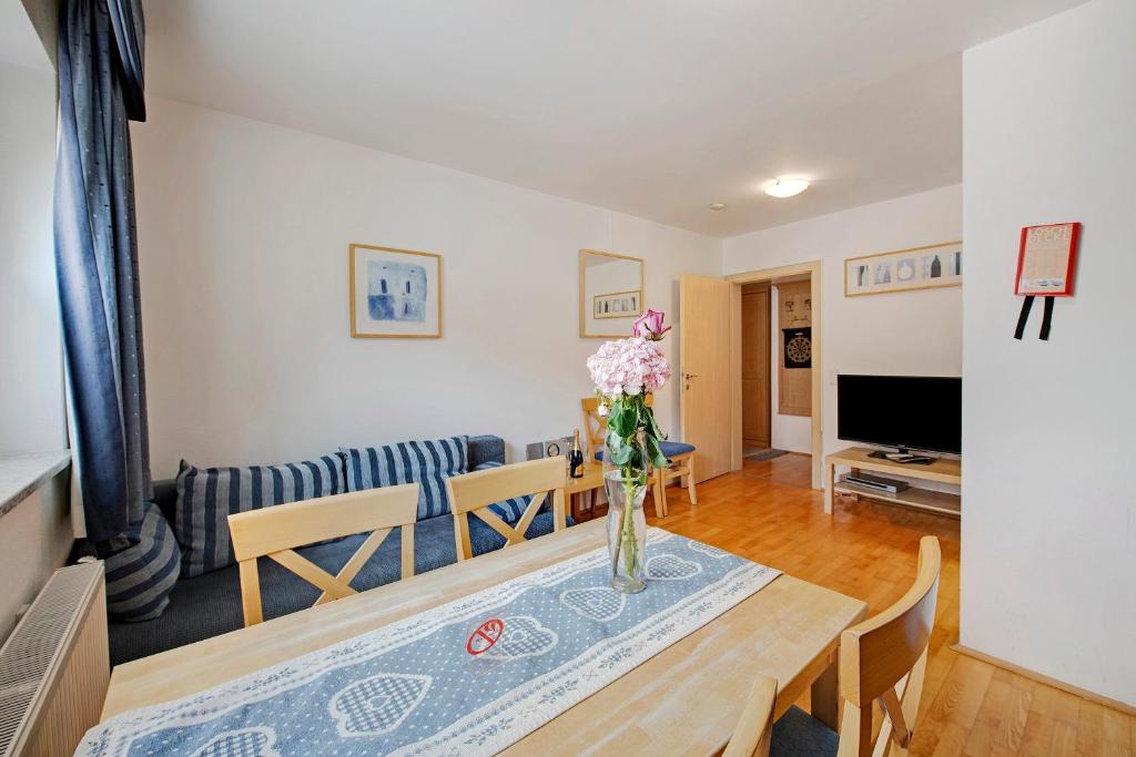 a living room with a table with a vase of flowers at Haus Lowe Appartement 1 Stock Nr 2 in Filzmoos