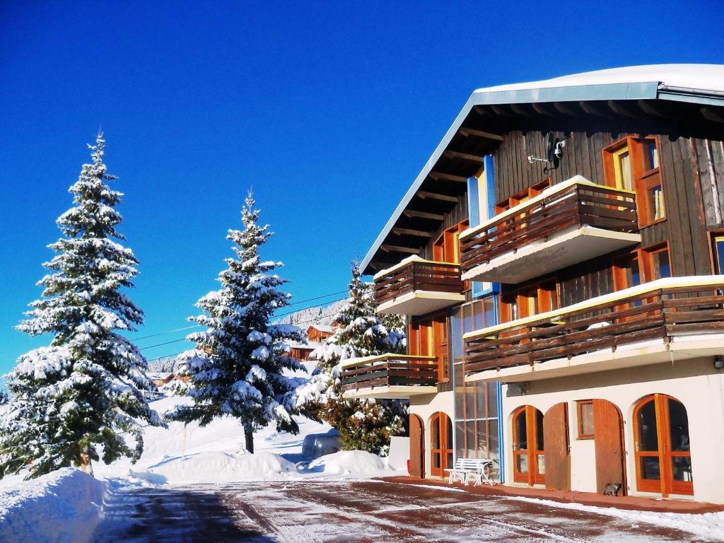 un edificio con árboles nevados delante de él en Le Chalet de Bisanne, en Les Saisies