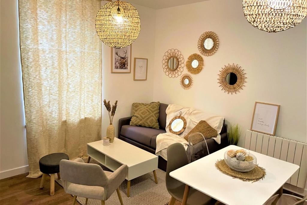 uma sala de estar com um sofá, mesas e espelhos em L'amiral n3 T2 nouvelle ville ByLocly em Lorient