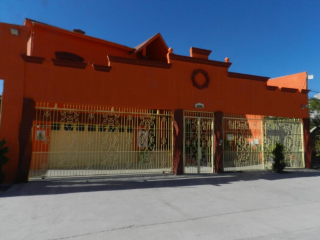 un edificio naranja con una puerta delante de él en Consul Suites, en Ciudad Juárez