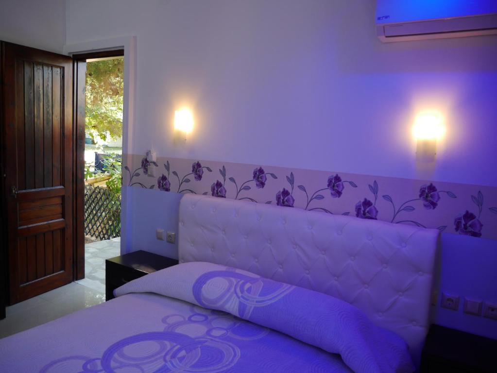 a purple bedroom with a bed with a purple headboard at Blue Bay Beach Hotel in Koinyra