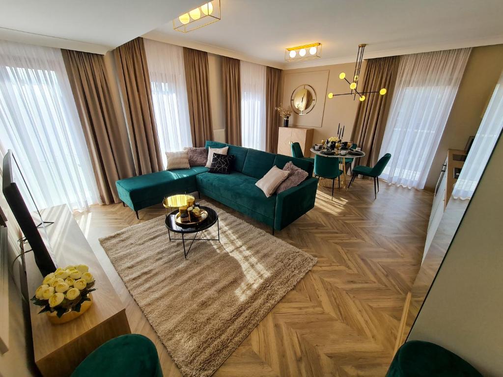 un soggiorno con divano verde e tavolo di Apartamenty Hallera 4 a Jarocin